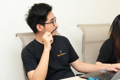 男人的黑水手领衬衫拿着黑色铅笔特写摄影
